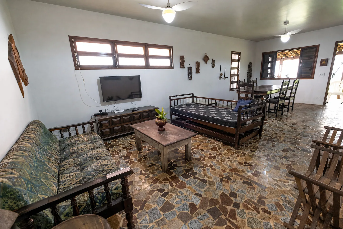 Sala de estar espaçosa com sofás, Smart TV e mesa de jantar